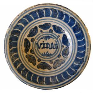 Detall d'un plat de ceràmica blava catalana decorada amb el motiu de la ditada.