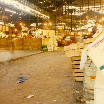 Treballador entre caixes de fusta dins el mercat