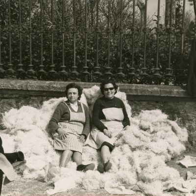 Mercè Pagés i Rosa Cendre al passeig Picasso, assegudes sobre un munt de palla